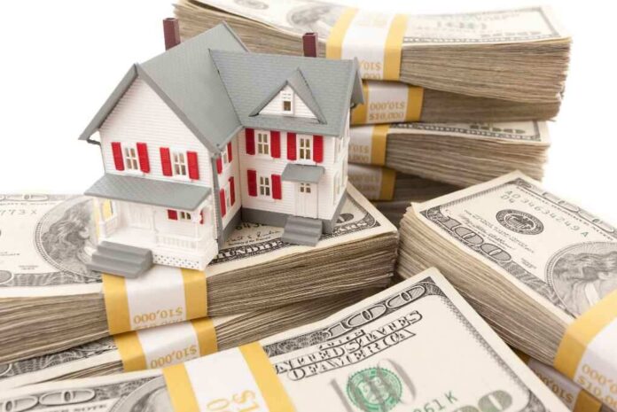 Small House with Stacks of Hundred Dollar Bills on White.